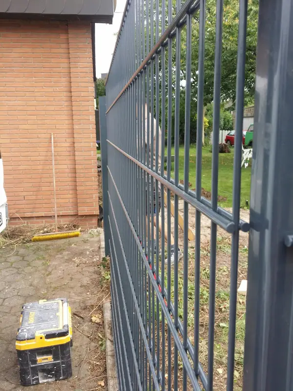 Ogrodzenie panelowe przy słupku, w&nbsp;trakcie montażu